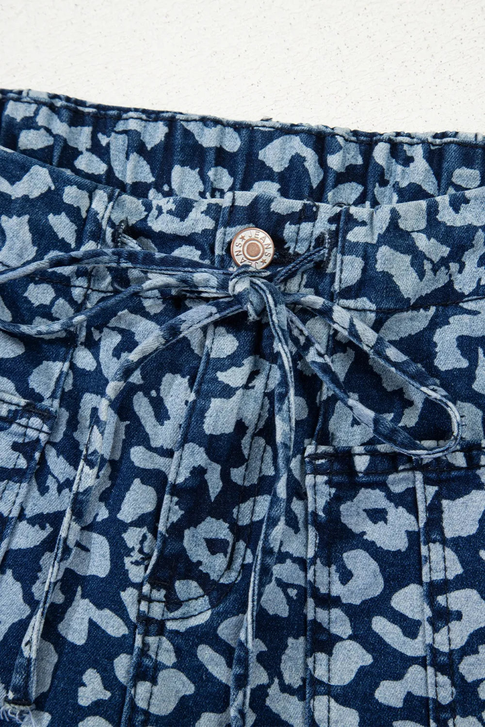 Close-up of a blue denim jacket with a subtle pattern on a white background