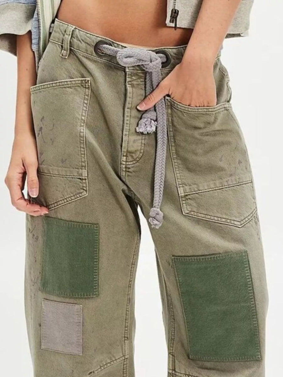 Model showing the pocket of green patched jeans