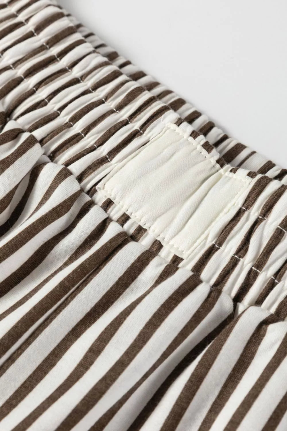 Close-up of brown and white striped fabric with a visible seam.