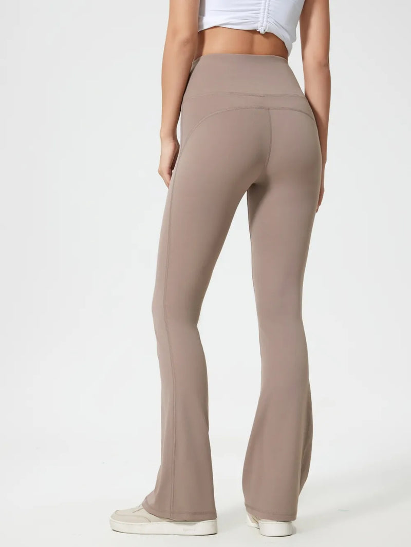 Beige flared pants worn by a person on a white background