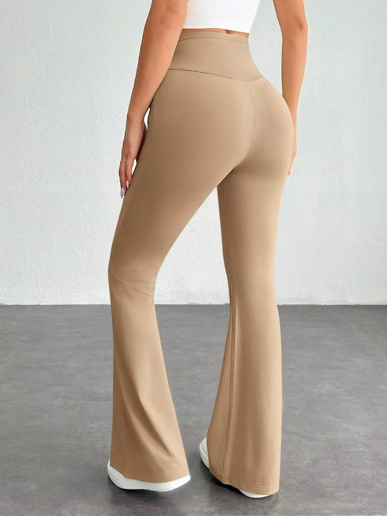 Beige flared pants worn by a person on a plain background