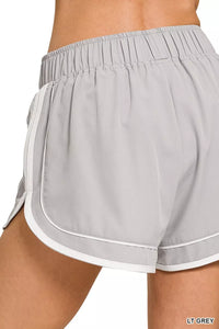 Light gray athletic shorts with white trim on a white background