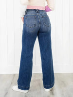 Person wearing blue jeans with a white background