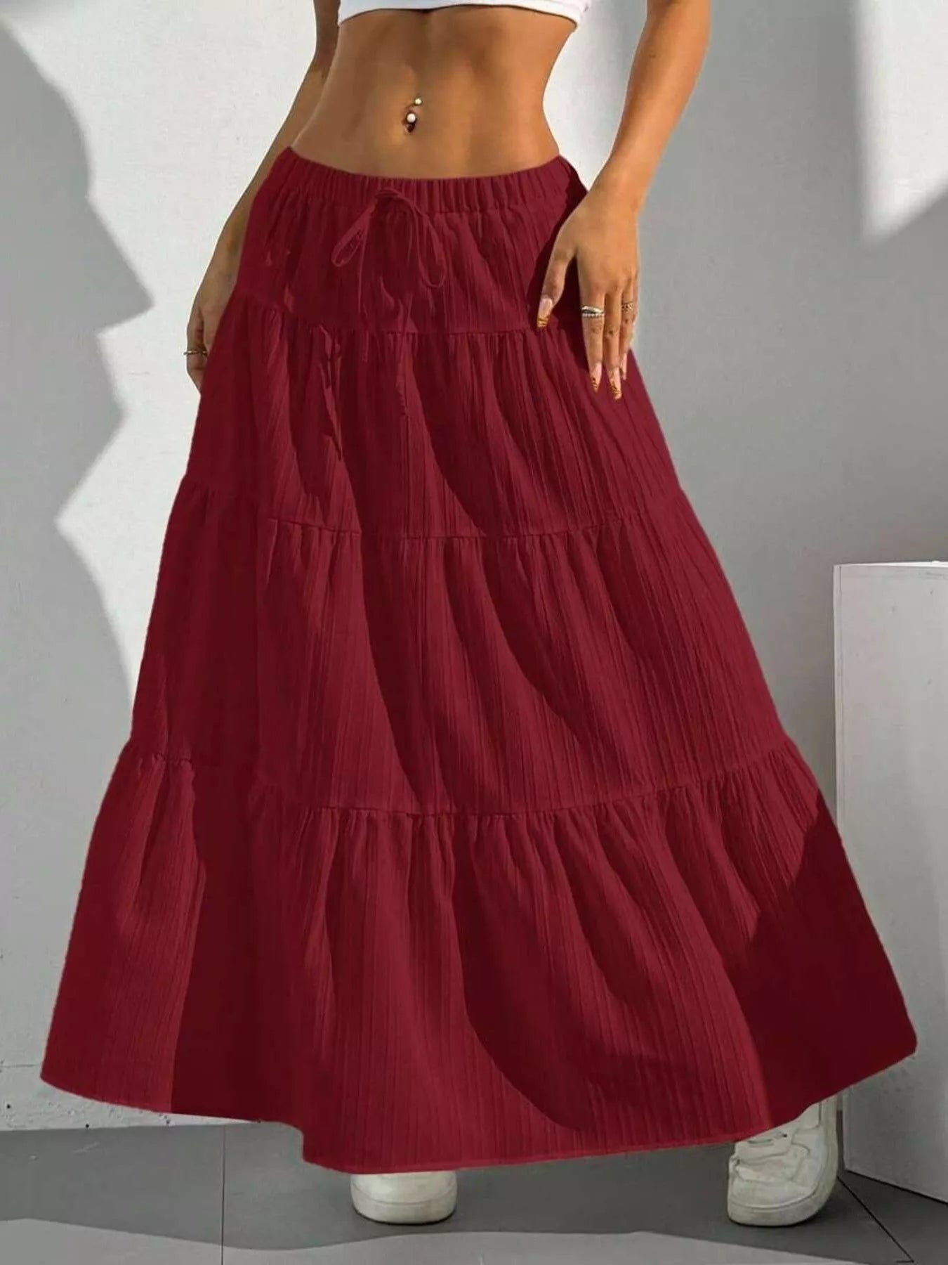 Red tiered skirt worn by a person on a gray background