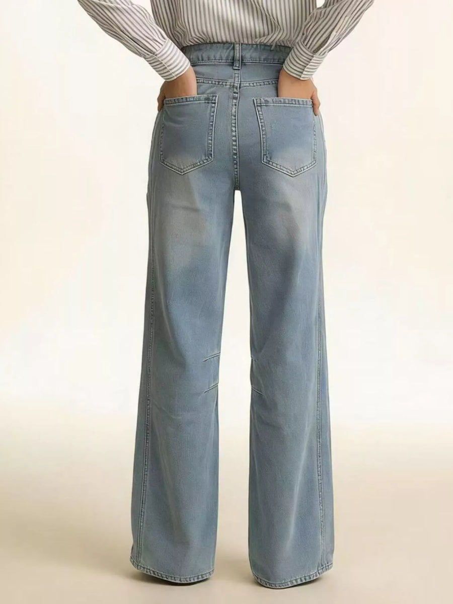 Light blue jeans worn by a person on a beige background