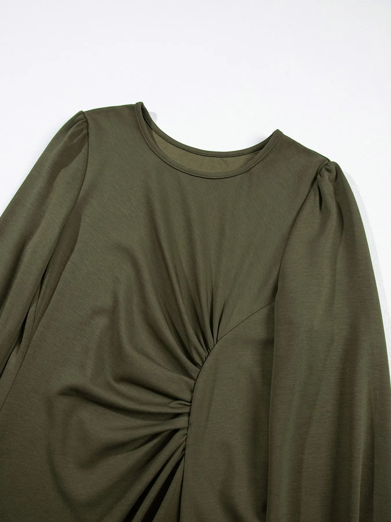 Green long-sleeve top with a knot detail on a white background