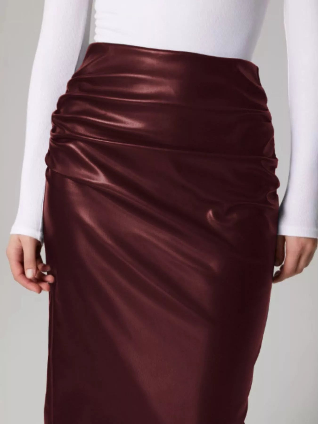 Maroon satin skirt worn by a person on a plain background