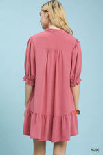 Woman wearing a pink dress against a light blue background