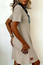 Beige dress with denim accents worn by a person on a white background