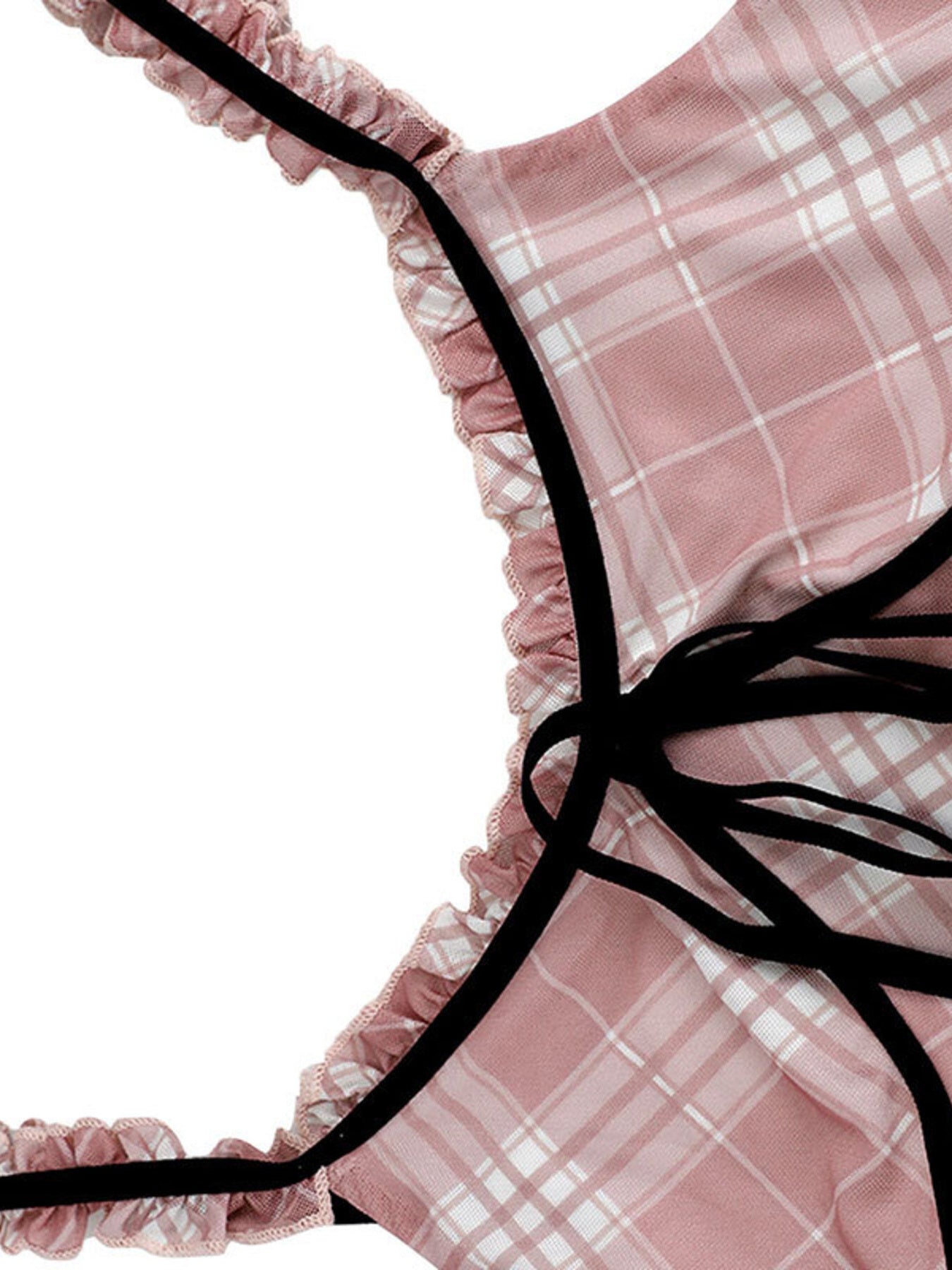 Close-up of a pink plaid garment with black ribbons on a white background