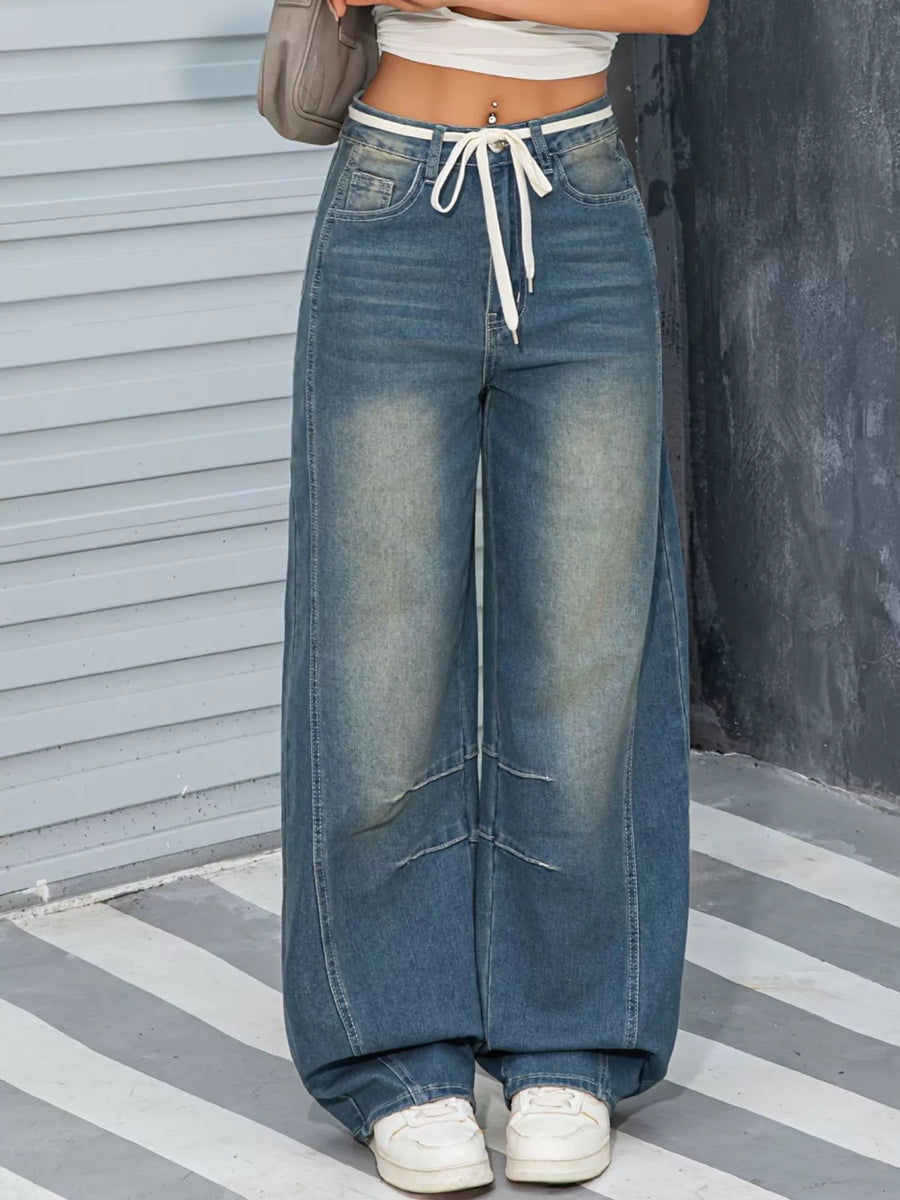 Person wearing wide-leg jeans with a neutral background
