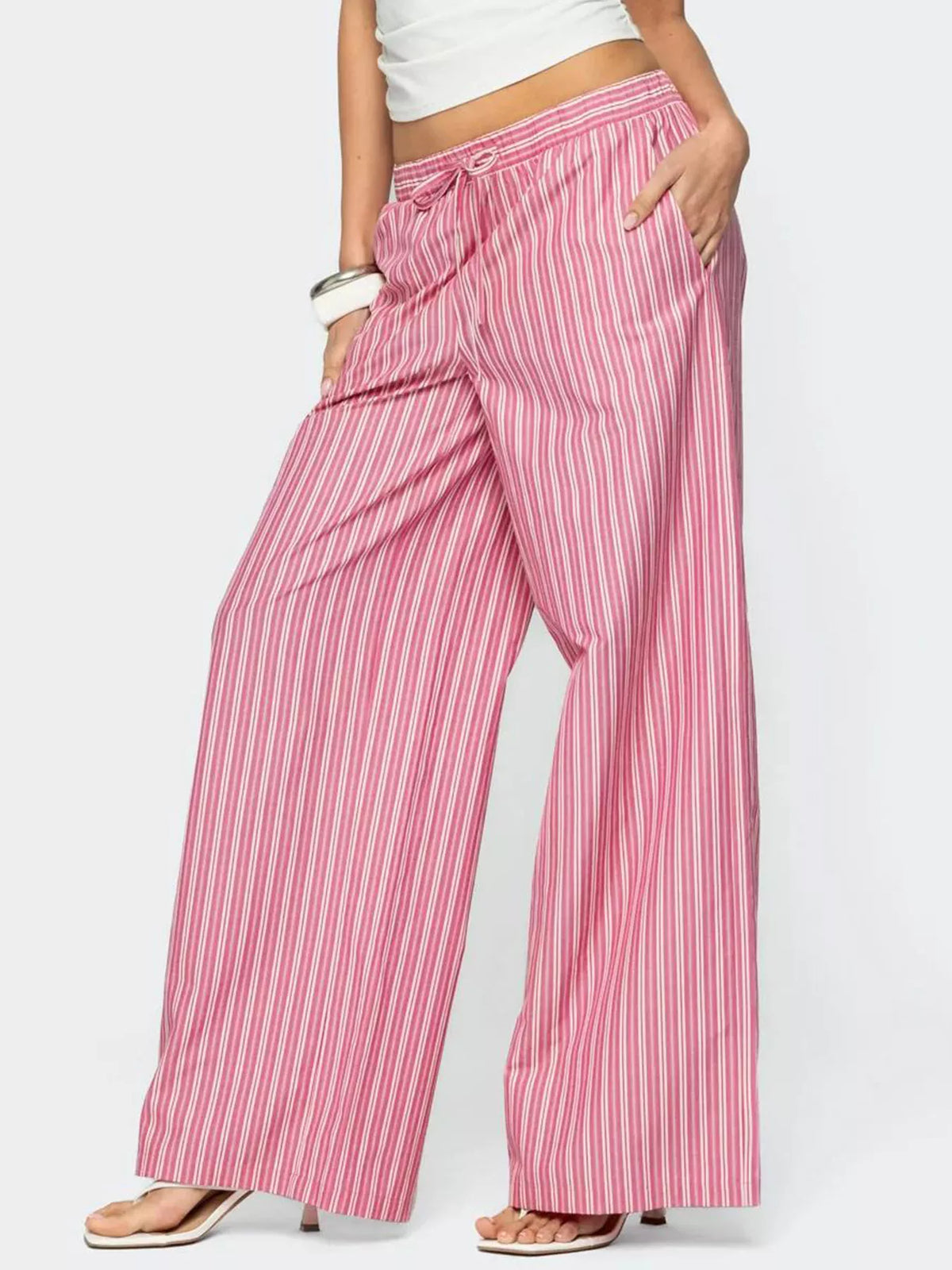 Person wearing pink and white striped pants on a plain background