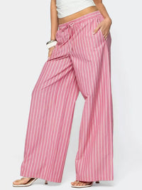 Person wearing pink and white striped pants on a plain background
