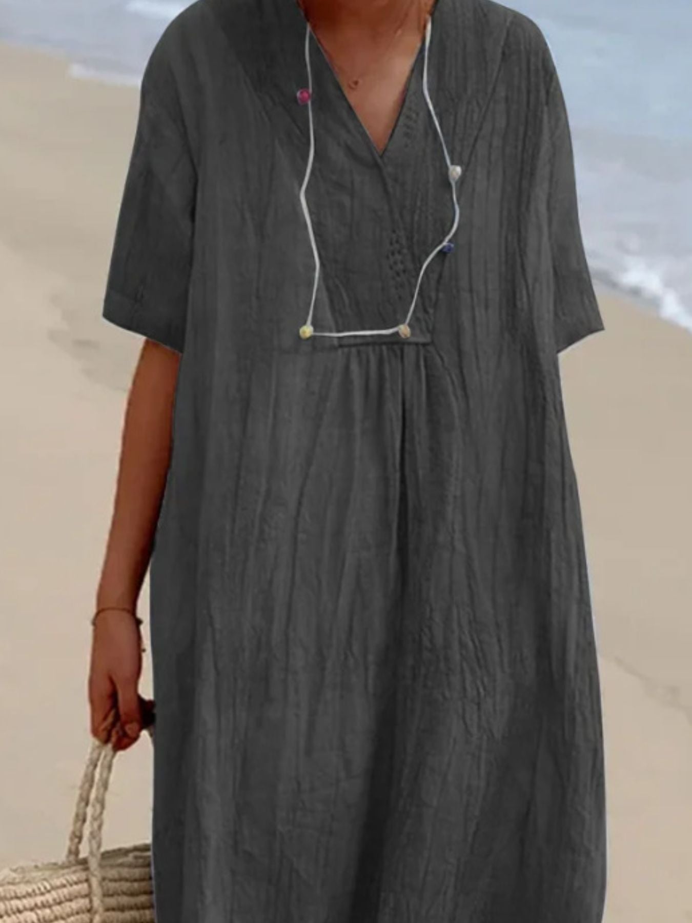 Person wearing a dark gray dress on a beach