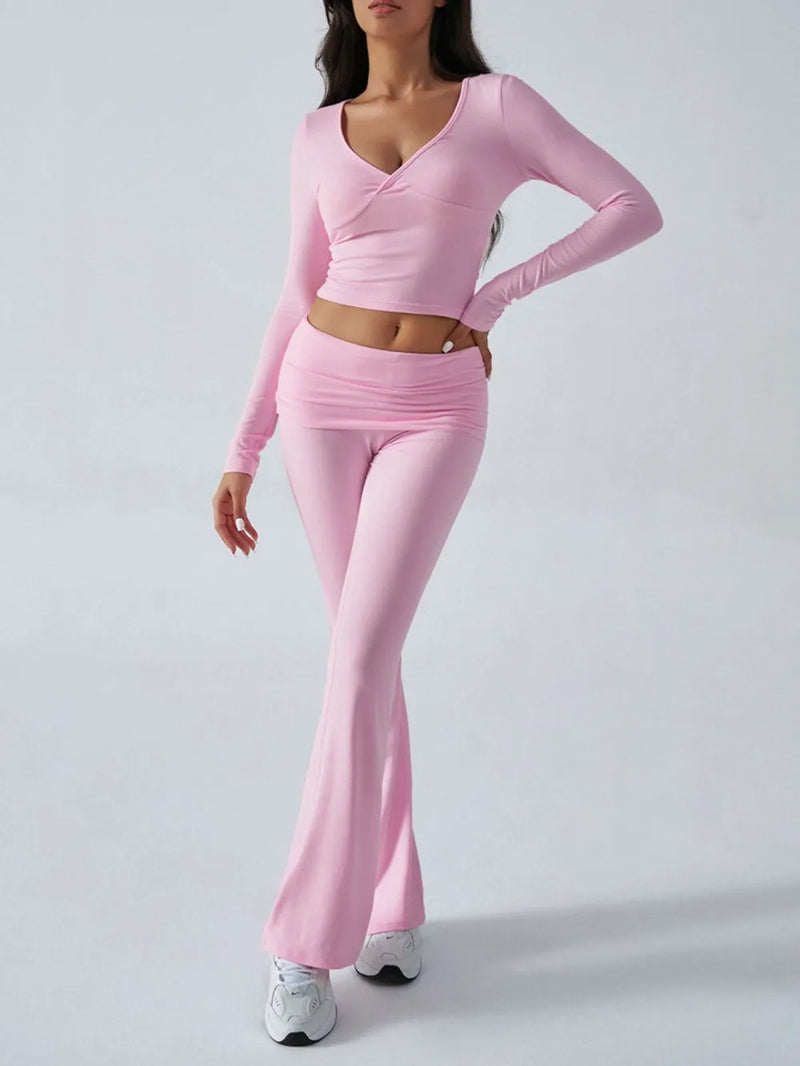 Person wearing a pink long-sleeve top and pants on a white background