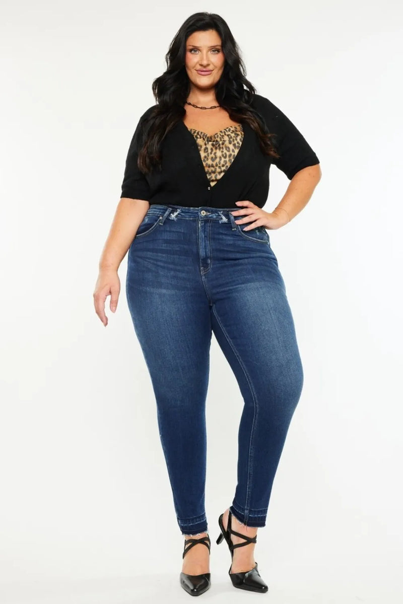 Woman wearing blue jeans and a black top with a leopard print heart design on a white background
