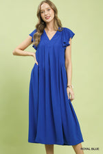 Woman wearing a blue dress on a light green background