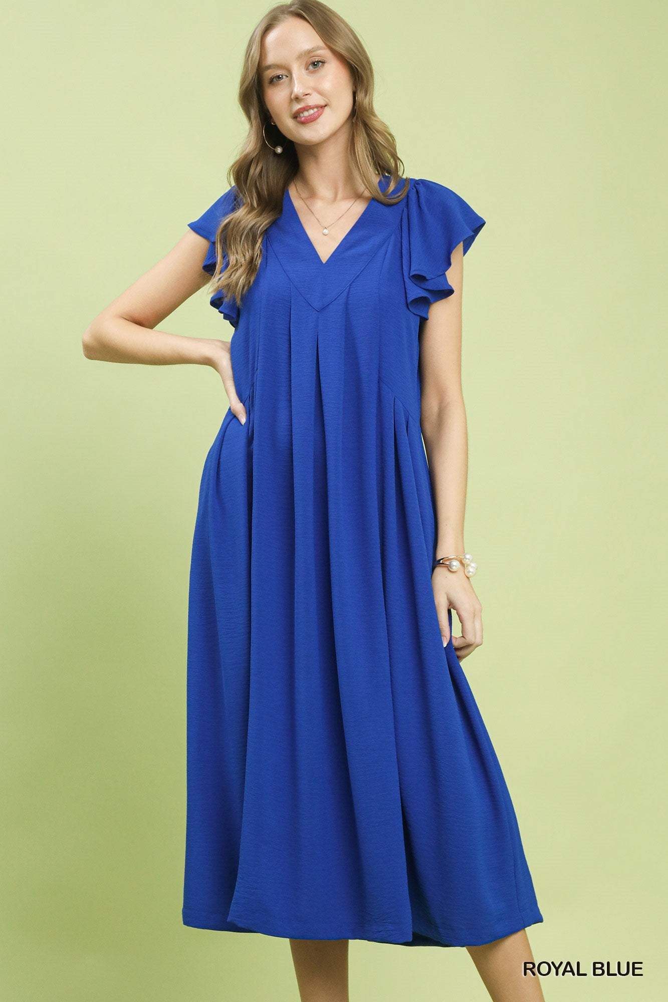 Woman wearing a blue dress on a light green background