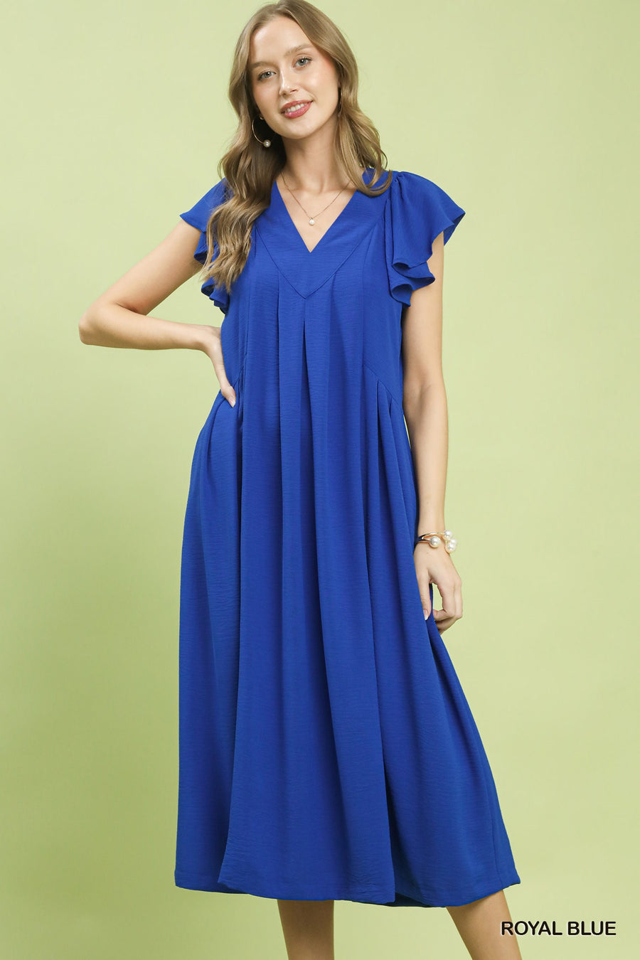 Woman wearing a blue dress on a light green background