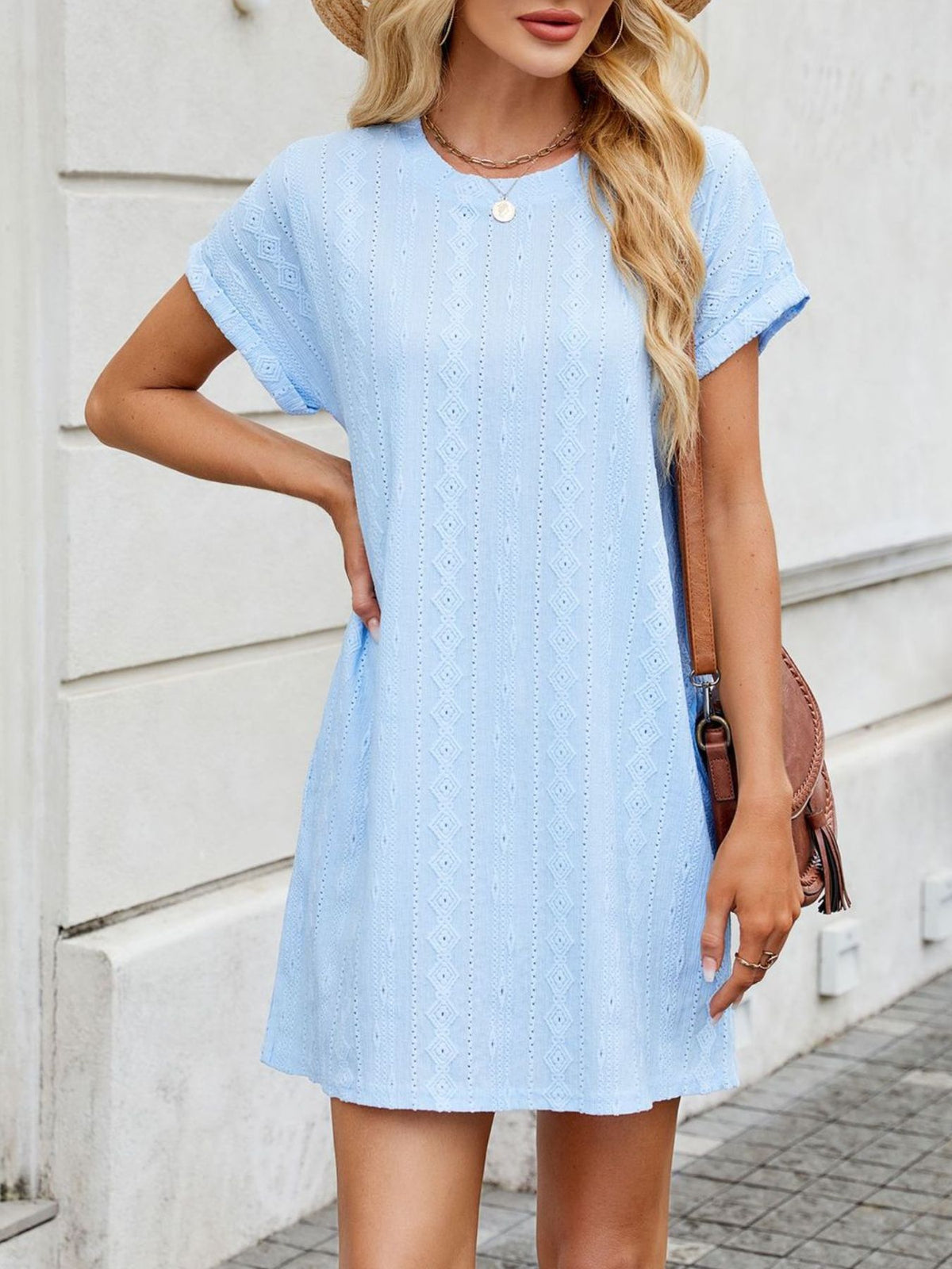 Woman wearing a light blue dress with a neutral background