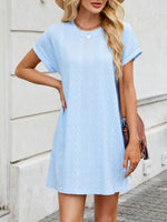Woman wearing a light blue dress with a neutral background