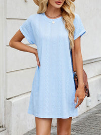 Woman wearing a light blue dress with a neutral background