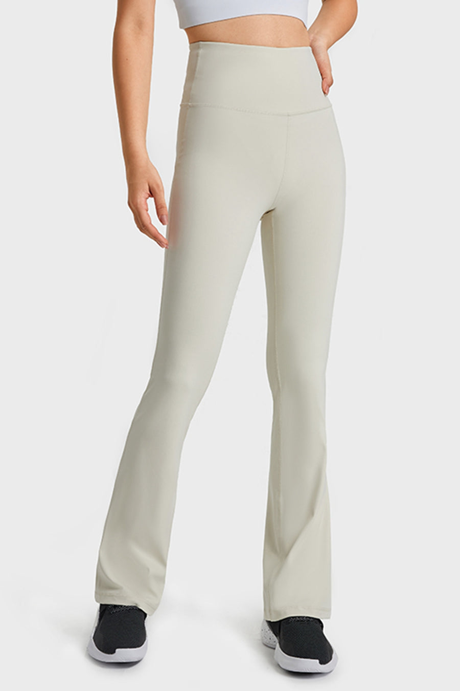 Beige high-waisted pants worn by a person on a white background