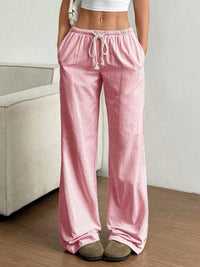 Person wearing pink striped pajama pants in a room with a neutral background