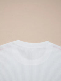 Close-up of a white ribbed sweater on a beige background
