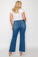 Person wearing blue jeans and a white shirt on a plain background