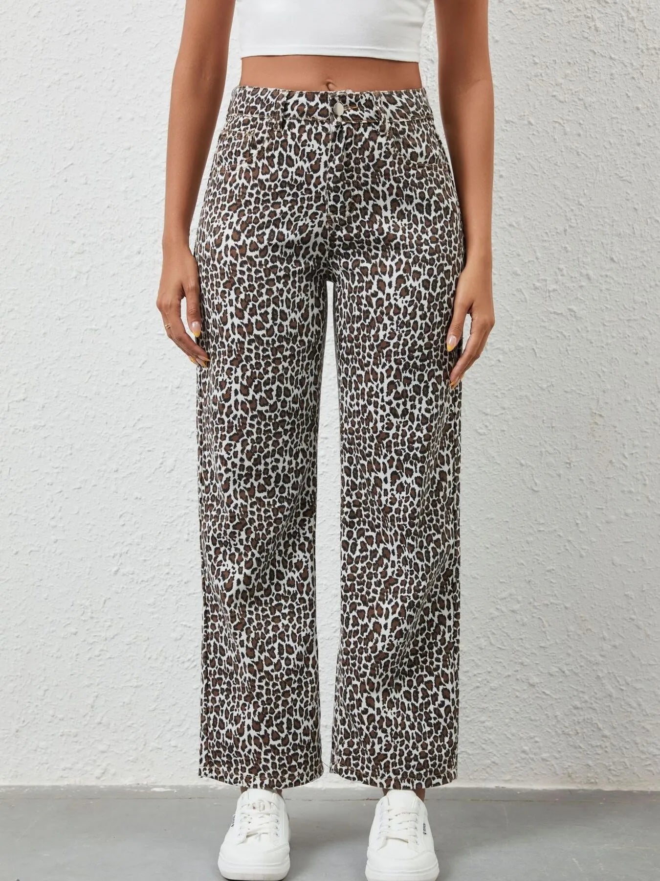 Person wearing leopard print pants against a white background