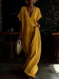 Person wearing a yellow dress in a dimly lit room with wooden furniture.