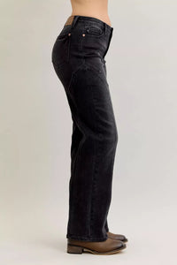 Black jeans worn by a person on a white background