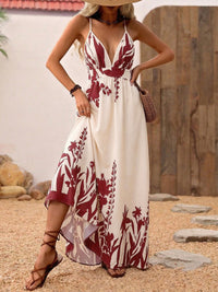 Woman wearing a white dress with red floral patterns on a stone path.