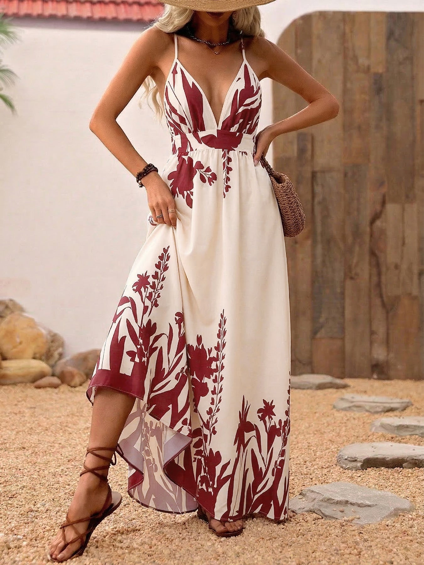 Woman wearing a white dress with red floral patterns on a stone path.
