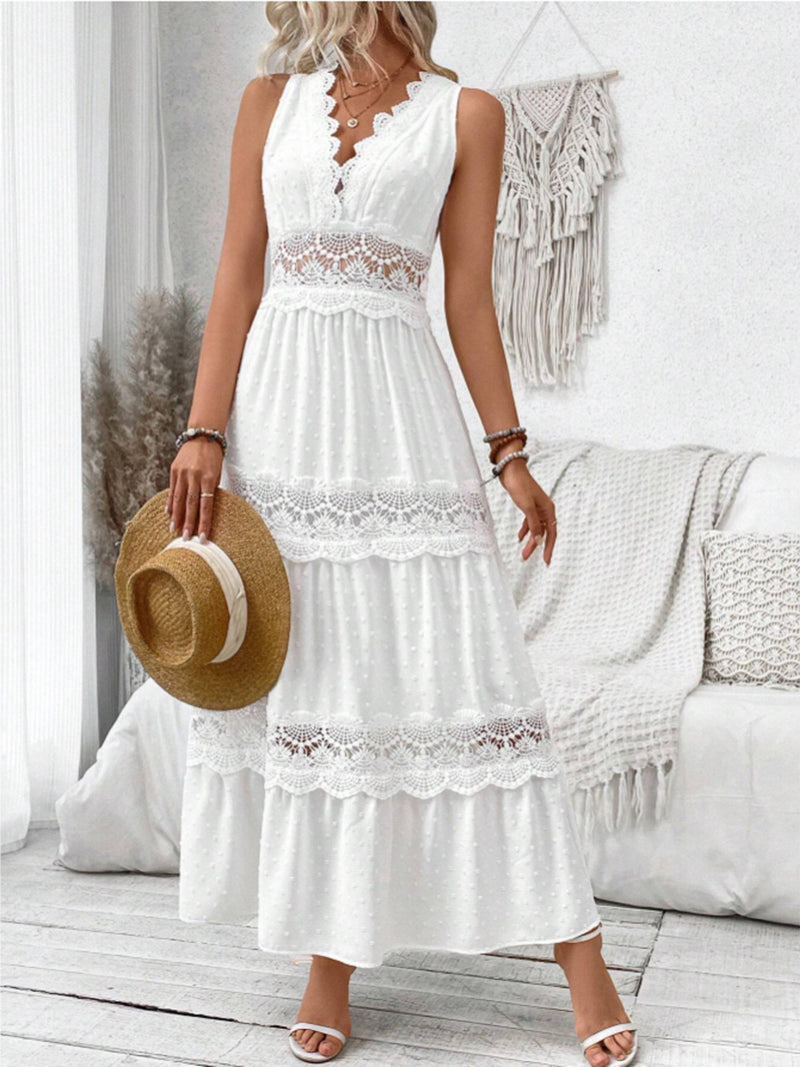 Woman wearing a white lace dress holding a straw hat in a bright room.