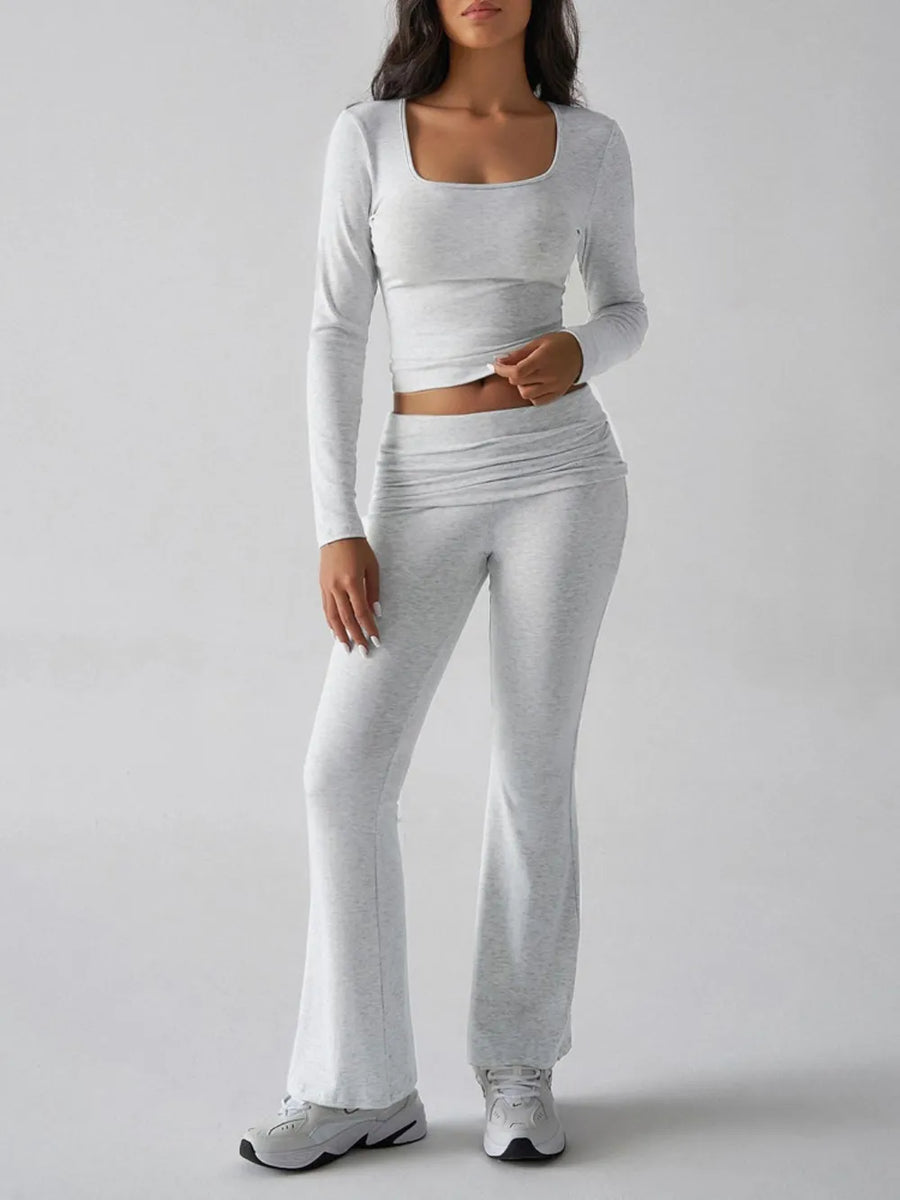 Person wearing a gray long-sleeve top and pants set on a light gray background