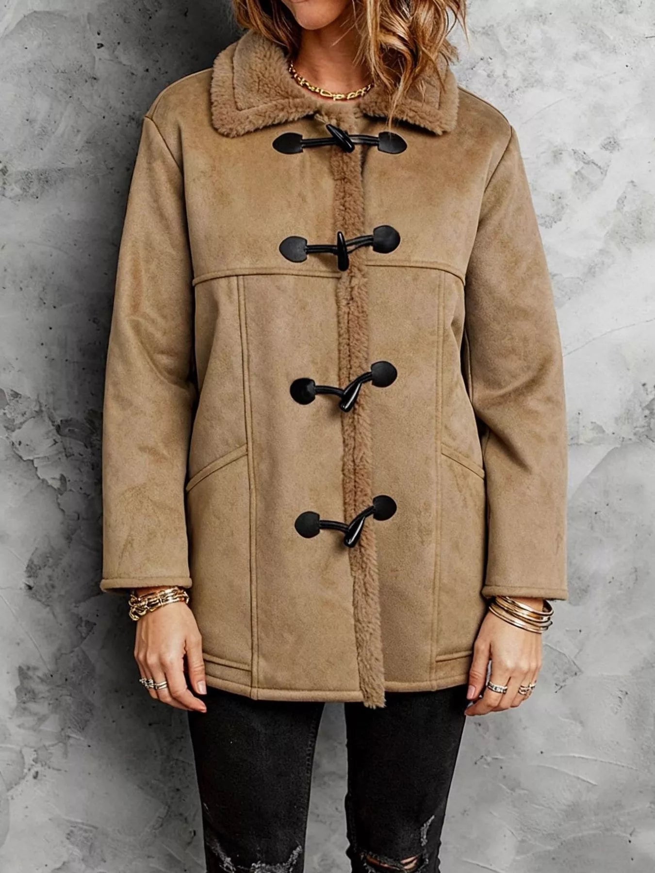 Tan duffel coat with black buttons on a gray background