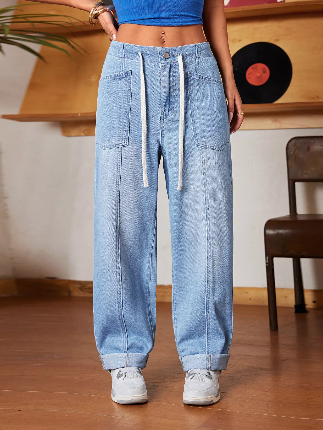 Person wearing light blue jeans and a blue top in a casual setting.