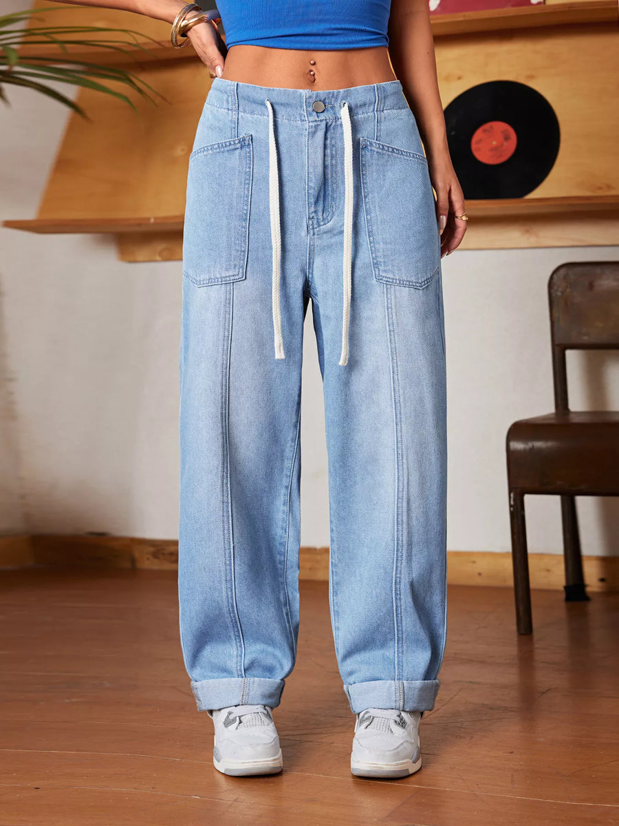 Person wearing light blue jeans and a blue top in a casual setting.