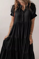 Person wearing a black dress with short sleeves against a neutral background