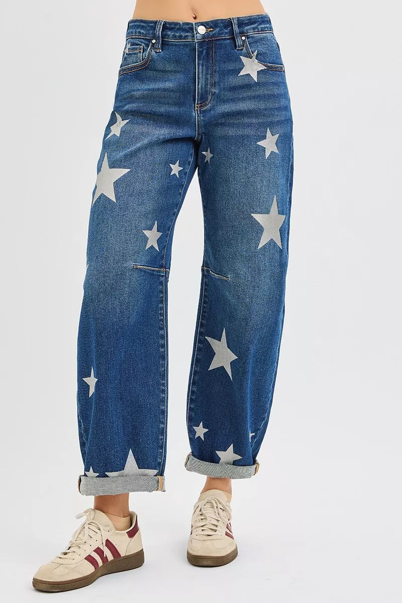 Blue jeans with star patterns worn by a person on a white background