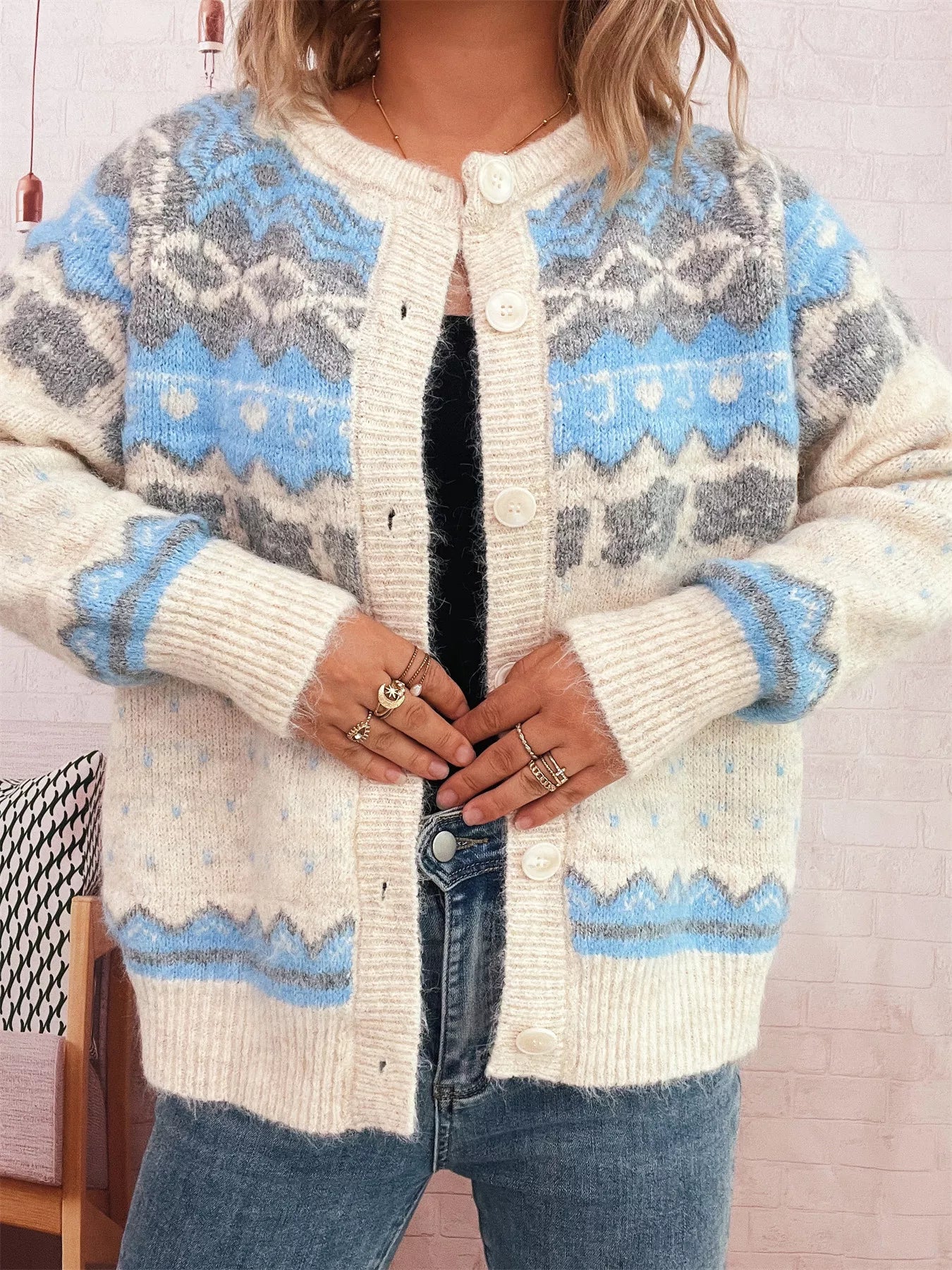 Person wearing a patterned cardigan with blue and gray designs.