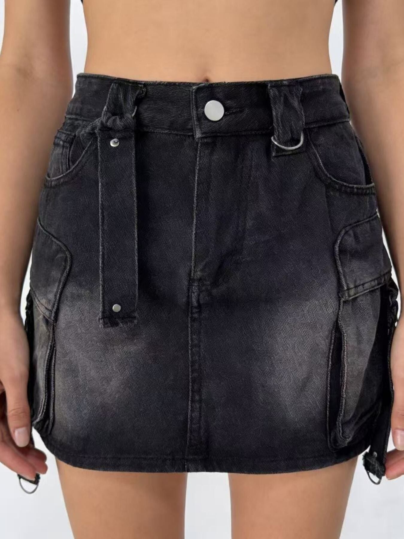 Black denim skirt worn by a person on a plain background