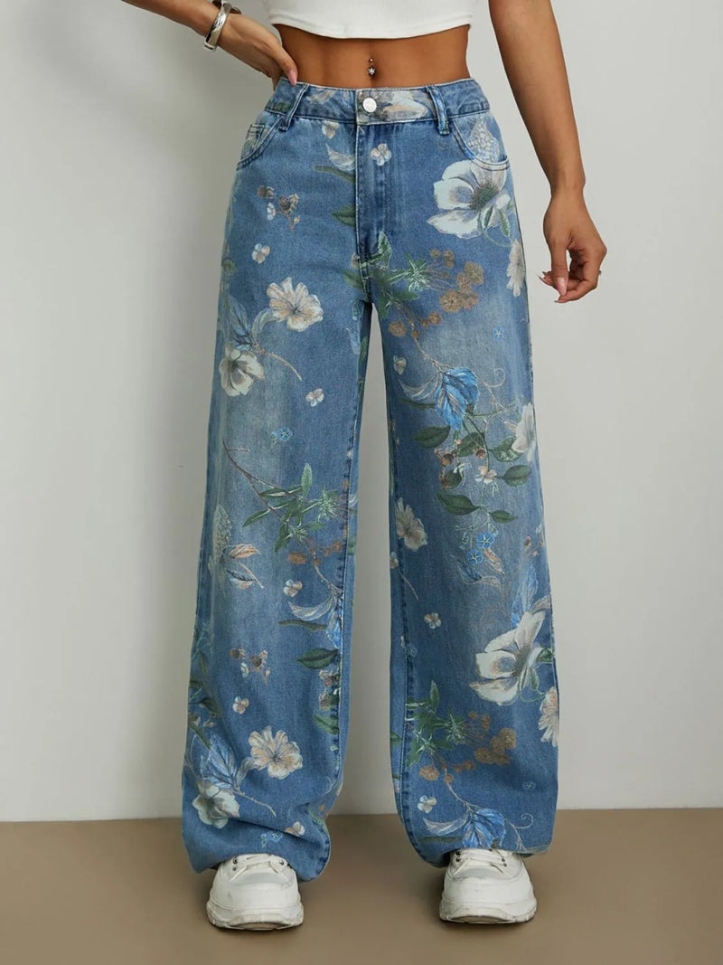 Person wearing blue floral jeans with a plain background