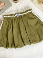 Green skirt with lace trim on a white surface