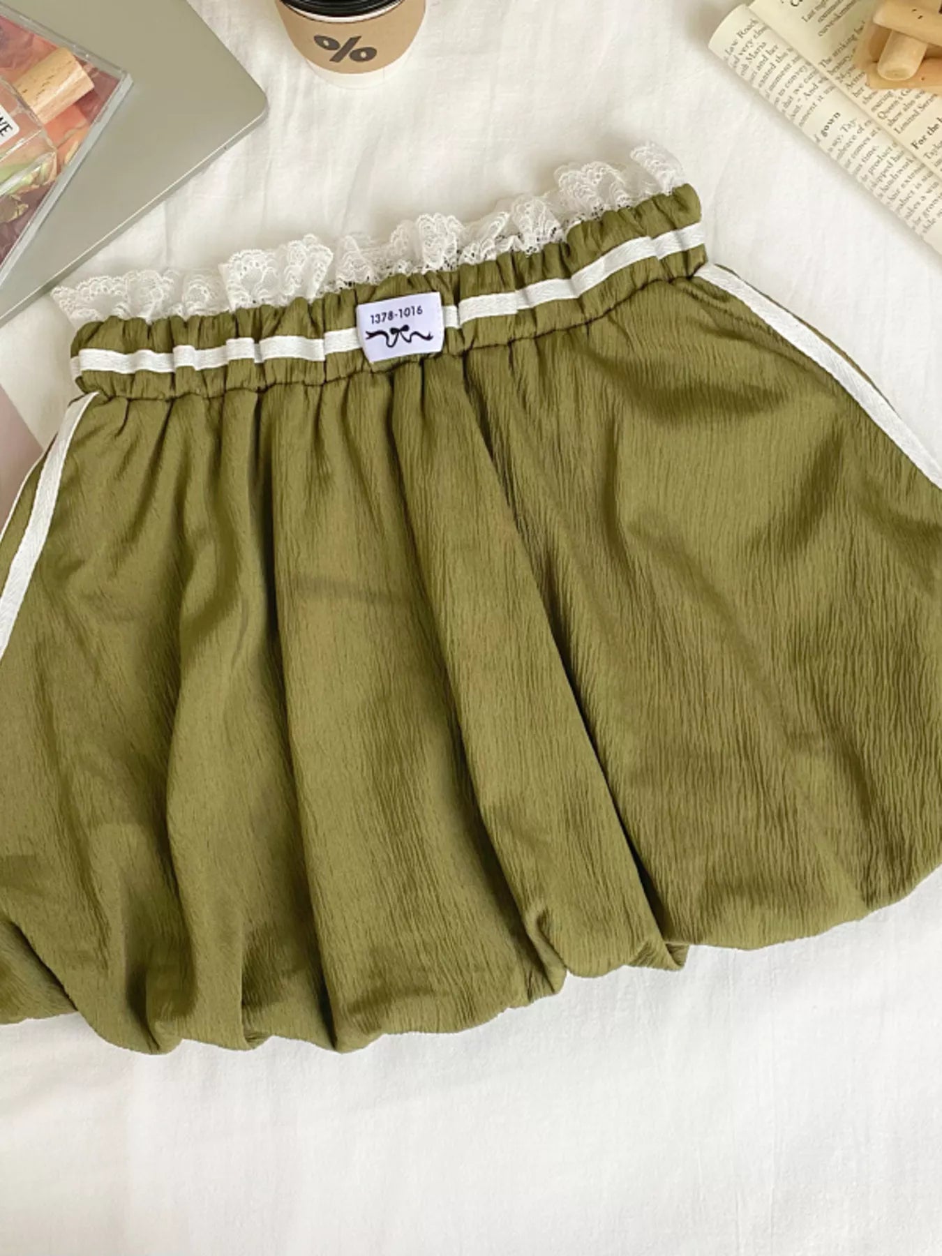 Green skirt with lace trim on a white surface