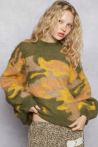 Woman wearing a camouflage sweater against a plain background