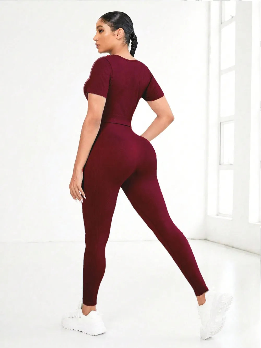 Woman wearing a maroon jumpsuit on a white background