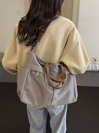Person wearing a beige sweater and light gray backpack with brown straps.